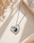 Crystal Heart photo projection necklace laying on cream stone