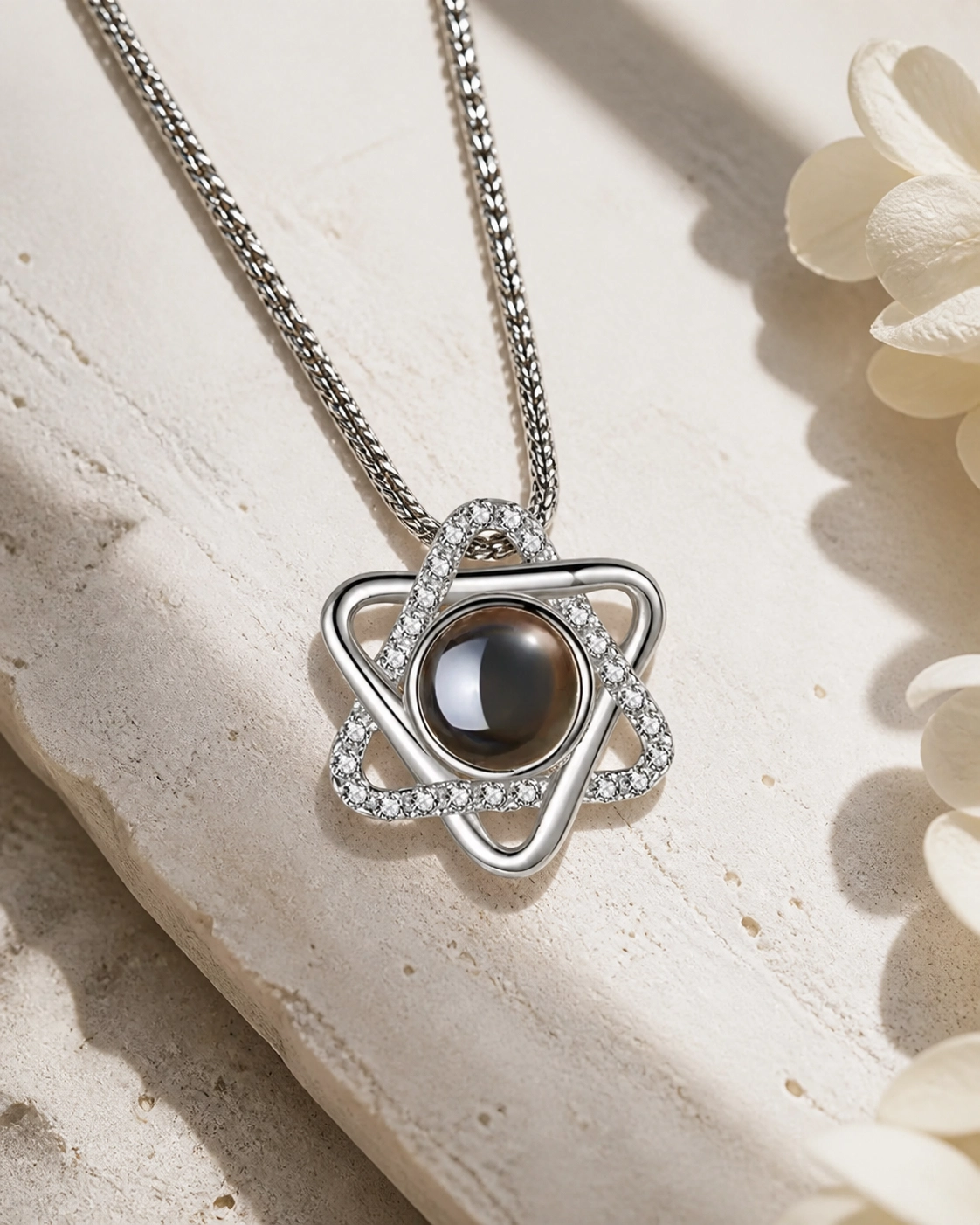 Hexed photo projection necklace laying on cream stone