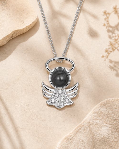 Little Angel photo projection necklace laying on cream stone